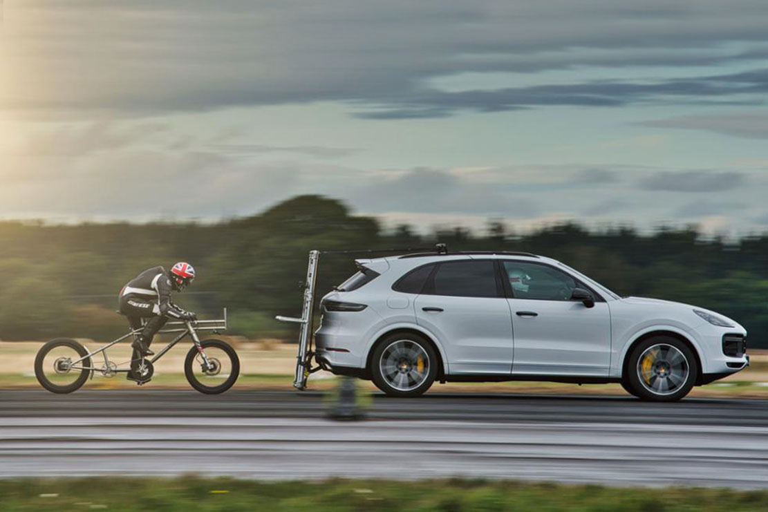 Image principale de l'actu: Record de vitesse en velo avec un porsche cayenne turbo 